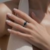 Primer plano de mano femenina luciendo un anillo acero en el dedo anular.