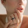Primer plano de mano de femenina luciendo un anillo acero en el dedo anular.