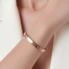 Modelo llevando pulsera rígida y articulada de acero 316L plateado.