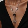 Mujer luciendo collar de cilindro en acero 316L plateado diseño italiano