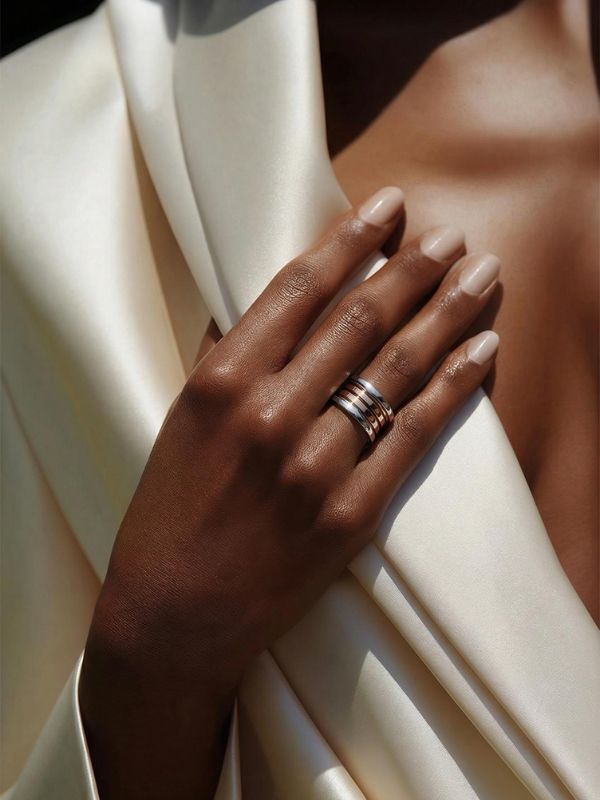 Primer plano de mano femenina luciendo un anillo acero en el dedo anular.