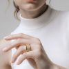 Primer plano de mano femenina luciendo un anillo acero en el dedo anular.