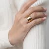 Primer plano de mano femenina luciendo un anillo acero en el dedo anular.