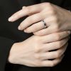 Primer plano de mano masculina luciendo un anillo acero en el dedo anular.