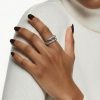 Primer plano de mano femenina luciendo un anillo acero en el dedo anular.