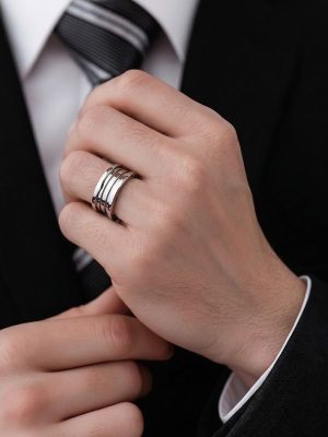 Primer plano de mano masculina luciendo un anillo acero en el dedo anular.