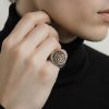 Primer plano de mano masculina luciendo un anillo acero en el dedo anular.