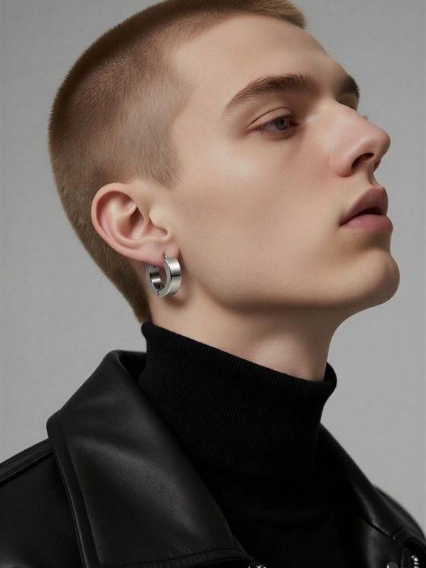 Modelo masculino de perfil luciendo un pendiente de aro de acero de 13mm en el lóbulo de la oreja con estilo urbano.