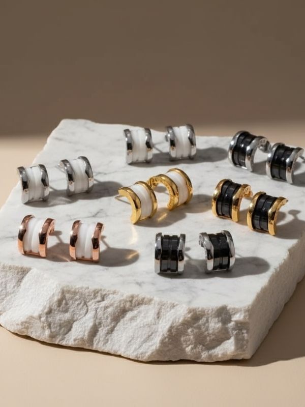 Pendientes de cerámica blanca o negra con forma curva y detalles en acero inoxidable 316L.
