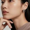 Pendientes Curvos Placer Acero 316L Cerámica 3 Modelo mujer luciendo pendientes curvos de cerámica negra y acero 316L plata en un ambiente de luz natural.