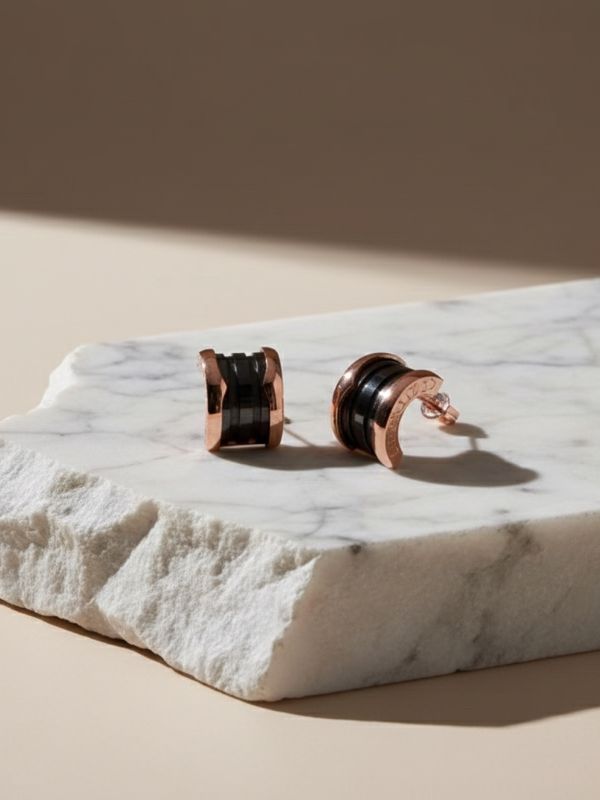 Pendientes de cerámica negra con forma curva y detalles en acero inoxidable 316L color oro rosa